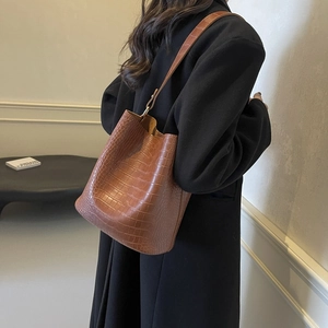 Brown crocodile embossed bucket bag featuring a large capacity and elegant leather texture