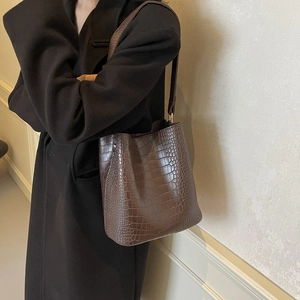 Brown crocodile embossed leather bucket bag with top handle and shoulder strap for work