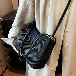 Black pleated bucket bag with long strap shown in a stylish everyday shoulder bag style