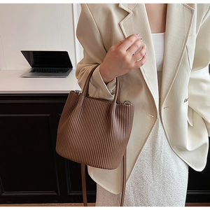 Brown pleated leather bucket bag detail with double handles and silver hardware for work