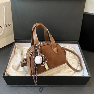 Vintage brown matte crossbody bag with top handle and baseball charm in a gift box