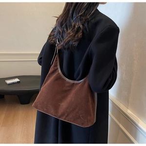 Detailed view of the brown suede hobo bag texture and subtle logo embossing