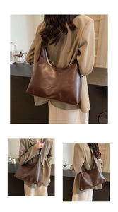 Detail of a deep brown vintage leather tote bag with a minimalist logo shoulder strap