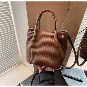 Detail of vintage brown pleated bucket bag showing textured synthetic leather and silver hardware
