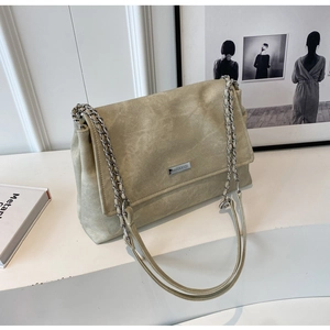 Detail of khaki suede shoulder bag with metallic chain strap and square logo plaque