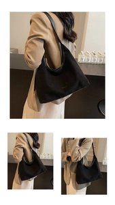 Detail of black suede hobo bag showing semi-moon shape and wide shoulder strap texture