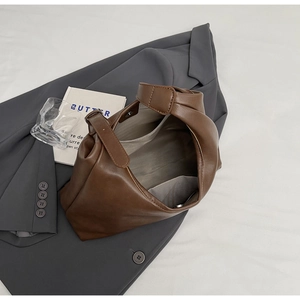 Detail view of large brown leather tote bag with fabric lining and interior pockets