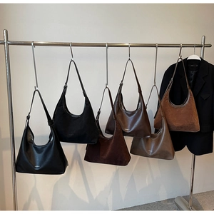 Detail shot of multi-color minimalist hobo bags on display with premium suede and leather finishes