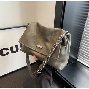 Detail of vintage grey textured tote bag with metal plaque and chain leather strap