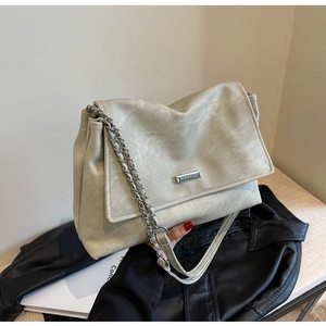 Detail of sage green chain flap bag with vintage texture and silver metallic logo