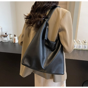Close-up of black pebble leather hobo bag showing soft texture and large capacity fit