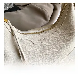 Close-up of lychee textured cream hobo bag showing gold zipper and debossed logo