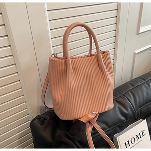 Detail showing pleated lotus pink bucket bag texture with silver hardware and strap