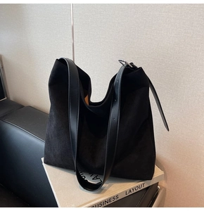 Detail of minimalist suede shoulder bag showing leather strap and metal buckle