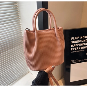 Detailed close-up of pleated texture on a pink bucket bag with leather-like finish