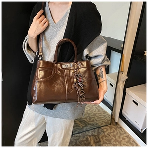 Detailed view of large dark brown tote bag with glossy finish and silver twist lock