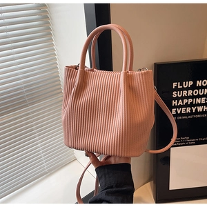 Detail of pink pleated bucket bag showing the unique vertical texture and soft PU leather