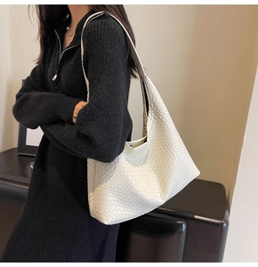 Detail of white woven hobo bag with leather texture and minimalist shoulder strap