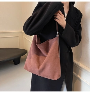 Detail view of large reddish brown suede tote bag showing its soft texture and slouchy shape