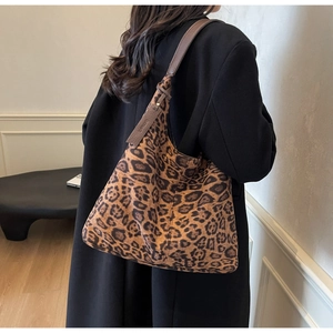 Detail of leopard print tote bag with soft suede texture and brown leather shoulder straps