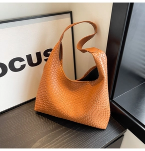 Close-up of caramel woven hobo bag showing wide Intrecciato pattern and texture