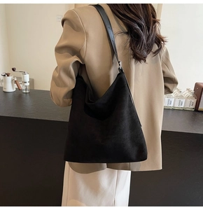 Side view of large black suede hobo bag on shoulder for daily commute look