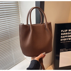 Detail showing deep brown pleated texture and round handle of this versatile bucket bag