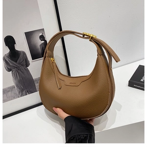 Detail of dark brown hobo bag showing litchi grain leather texture and brand embossing