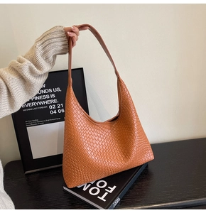 Detailed close-up of brown woven leather hobo bag with a spacious triangular design