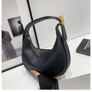 Detailed close-up of black litchi grain leather half-moon bag with golden metal hardware
