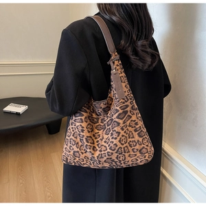 Detail of leopard print tote bag with brown leather strap and side leather tag