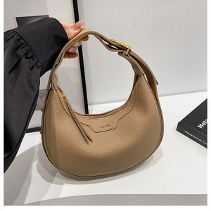 Detail of khaki crescent saddle bag in pebble grain leather with gold hardware adjustment
