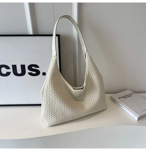 Close-up of cream woven faux leather tote bag showing intricate checkered texture