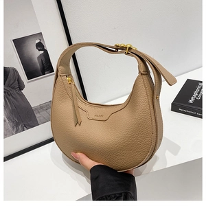 Detailed close-up of light brown lychee grain leather hobo bag with gold hardware
