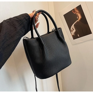 Macro detail of black pleated bucket bag with vertical textured synthetic leather