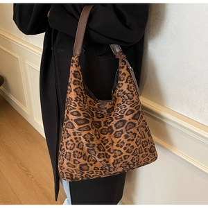 Fashionable leopard print tote bag styled with a black coat in a minimalist interior