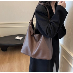 Close-up of a large dark brown hobo shoulder bag with litchi grain leather and hangtag