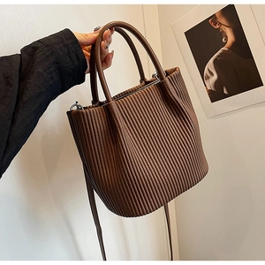 Close-up of a pleated dark brown bucket bag with fine accordion texture and silver hardware