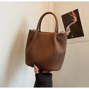 Close-up of brown pleated texture and vertical embossed details on the bucket handbag