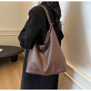 Detailed view of the brown pebbled leather texture on a large minimalist shoulder tote bag