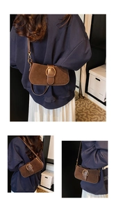 Detailed close-up of brown suede shoulder bag with vintage metal buckle and adjustable strap