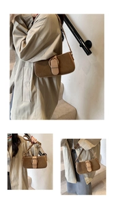 Detail of vintage brown suede baguette bag with gold horseshoe buckle and slim strap
