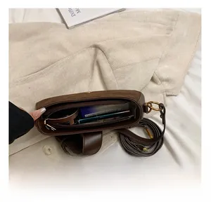Spacious brown underarm bag interior showing storage space for cosmetics and essentials