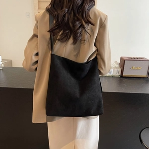 Minimalist large black suede tote bag for women showing a sleek commuter shoulder style