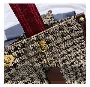 Close-up of golden hardware clasp and vintage textured fabric on a stylish tote bag