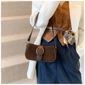 Detail of a dark brown vintage underarm bag with a large gold ring buckle and matte finish