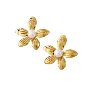 Elegant gold flower earrings with white pearl center and textured metal petals on white backdrop