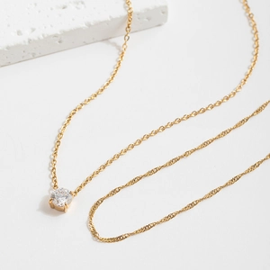 Double layered gold stainless steel necklace featuring a round cubic zirconia solitaire
