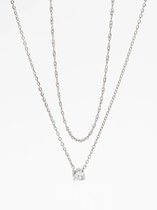 Detail of layered silver stainless steel necklace with sparkling round diamond pendant