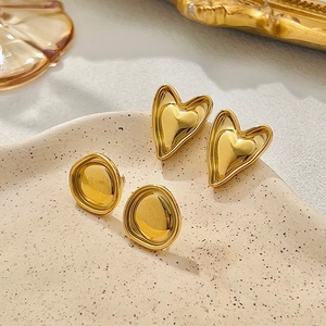 Ensemble de boucles d'oreilles dorées en acier inoxydable sur un plateau céramique